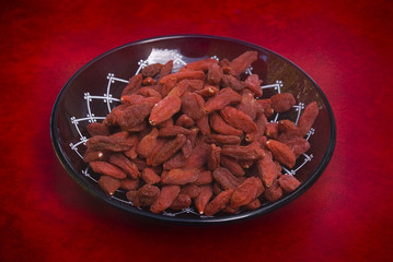 dry goji berries (Lycium barbarum) on red background