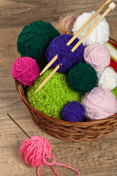 Colorful yarn balls in wicker basket. Selective focus.