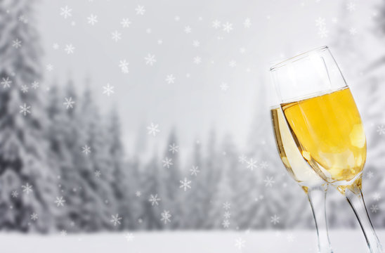 Glasses with champagne against winter background
