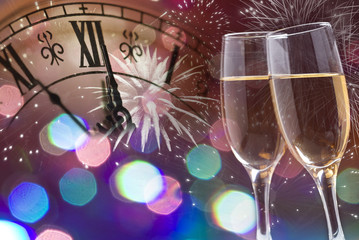 Glasses with champagne and clock close to midnight