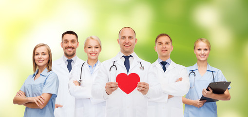 group of smiling doctors with red heart shape