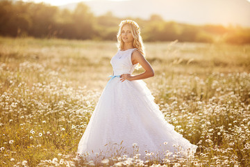 beautiful girl in dress on the daisy flowers field