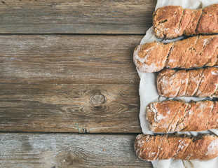 Obraz na płótnie Canvas Freshly baked rustic village bread (baguettes) set on rough woo
