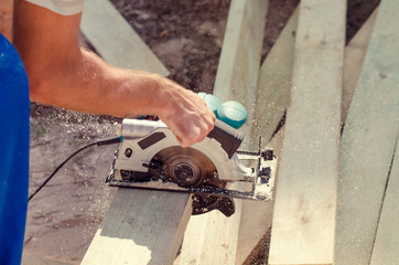 Workman cutting a wooden beam