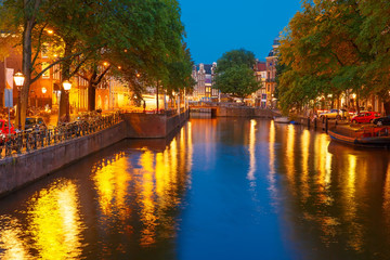 Naklejka premium Night city view of Amsterdam canal and bridge