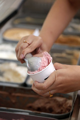 Hand scooping ice-cream to the cup