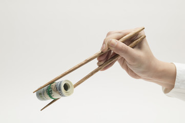 Women are grabbing the $ 100 wad with chopsticks
