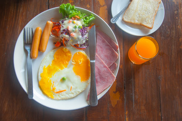 breakfast with fried eggs, toasts, juice and salad