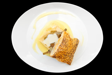 Bun with braised artichoke on oval plate isolated on black