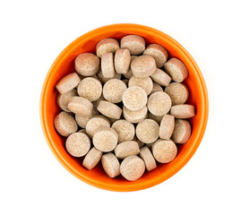 Orange herbal multi-vitamin pill tablets against white