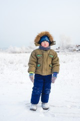 Little boy with a sad face outdoors winter outdoors