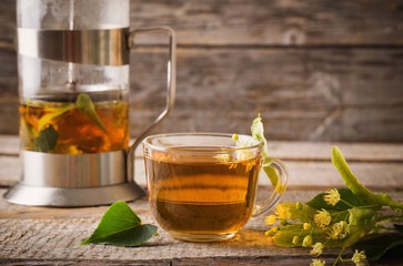 cup of tea with linden on wooden background