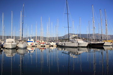 sail Boats and yachts reflected in calm marina