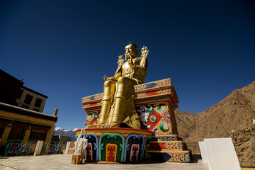 Golden Maitreya Buddha statue on blue sky