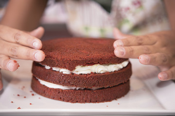 Young woman chef cooking cake in kitchen