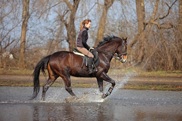 Woman rides in shallow water
