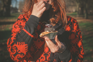 Woman in park with cupcake
