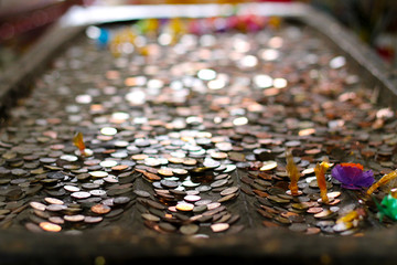 coin on statue of Bhddha's foots
