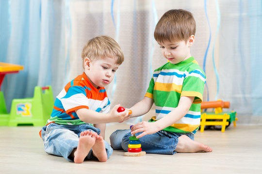 children brothers play together in nursery