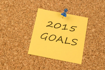 Yellow sticky note on an office cork board. 2015 Goals