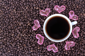 cup of coffee with hearts on the background of coffee beans