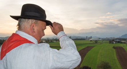 Man wearing traditional clothing looking at fields