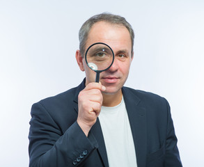 Businessman looking through magnifying glass