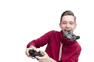 Fototapeta na wymiar Young guy playing video game funny holding joystick in his mouth