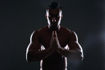 Fototapeta na wymiar Silhouette of a muscular man praying