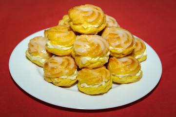 Cream puff pile on white plate