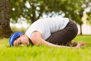 Fototapeta na wymiar Brunette relaxing and meditating on grass