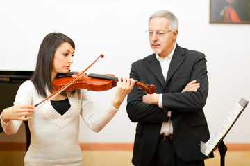 Obraz premium Violin teacher helping a student