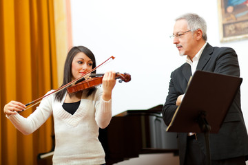 Violin teacher helping a student