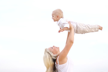 Happy Mom and baby son in summer nature