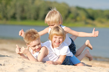 Fototapeta na wymiar Portrait of three children playing on the beach
