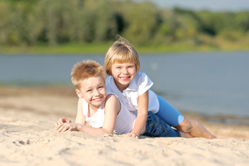 Fototapeta na wymiar Portrait of a boy and girl on the beach in summer