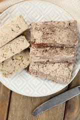 Two kinds of sunflower halva on plate, on wooden background