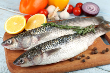 Fresh raw fish and food ingredients on table