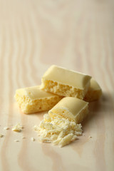 Tasty white porous chocolate on wooden table, close up