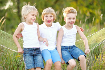 Fototapeta premium three children playing on meadow in summer
