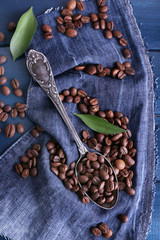 Green petal near the spoon of coffee beans