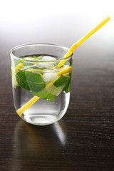 Summer cocktail with ice cubes on wooden table