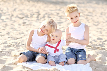 Fototapeta na wymiar portrait of three little boys on the beach in summer
