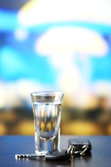 Glass of alcoholic drink and car key,