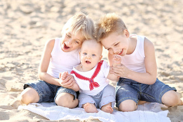 Naklejka na ściany i meble portrait of three little boys on the beach in summer