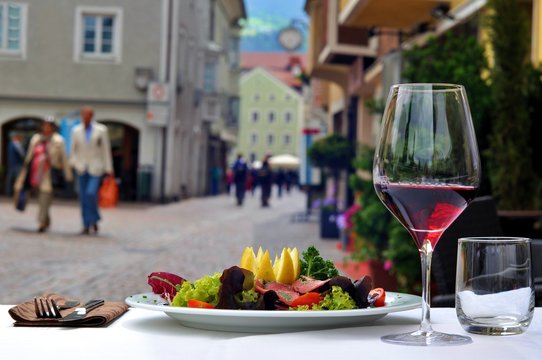 Composition with red wine and food in open restaurant