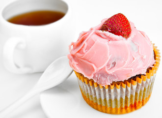 Fruitcake with a berry and a cup of tea