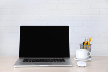 Modern laptop on table, on white wall background