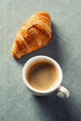 Breakfast concept: cup of coffee and croissant
