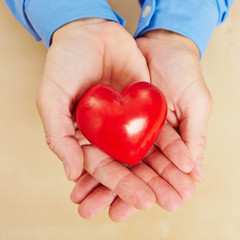 Mann hält rotes Herz in seinen Händen